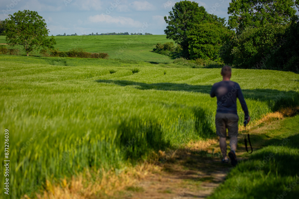 Lush green countryside in spring with an unfocused figure Lush green countryside in spring with an unfocused figure