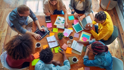 Top view of a diverse and creative team collaborating at a bright, colorful workspace with various tools. AIG53M photo