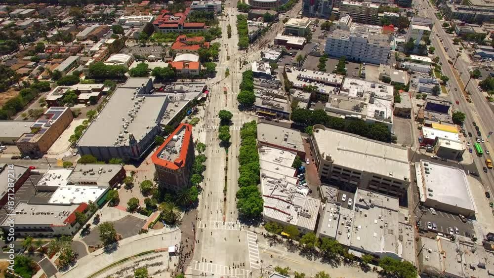 Aerial Tilt Down Shot Of People Cycling By The Culver Hotel In City On Sunny Day - Los Angeles, California