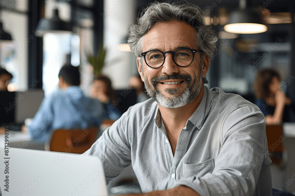 Portrait of Mature Indian or Latin Businessman Sitting at Desk with Laptop in Modern Office, Smiling Middle-aged Male Teacher Wearing Glasses Working and Teaching Students Portrait of Mature Indian or Latin Businessman Sitting at Desk with Laptop in Modern Office, Smiling Middle-aged Male Teacher Wearing Glasses Working and Teaching Students