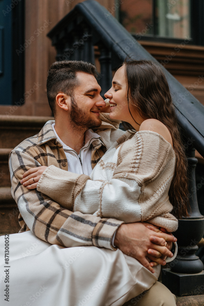 Couple sitting on steps of brownstone building, enjoying each others company Couple sitting on steps of brownstone building, enjoying each others company