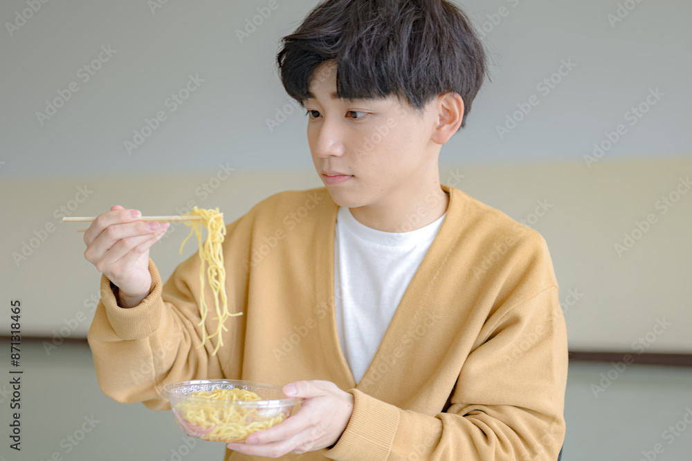 麺を持ち上げる若い男性 麺を持ち上げる若い男性