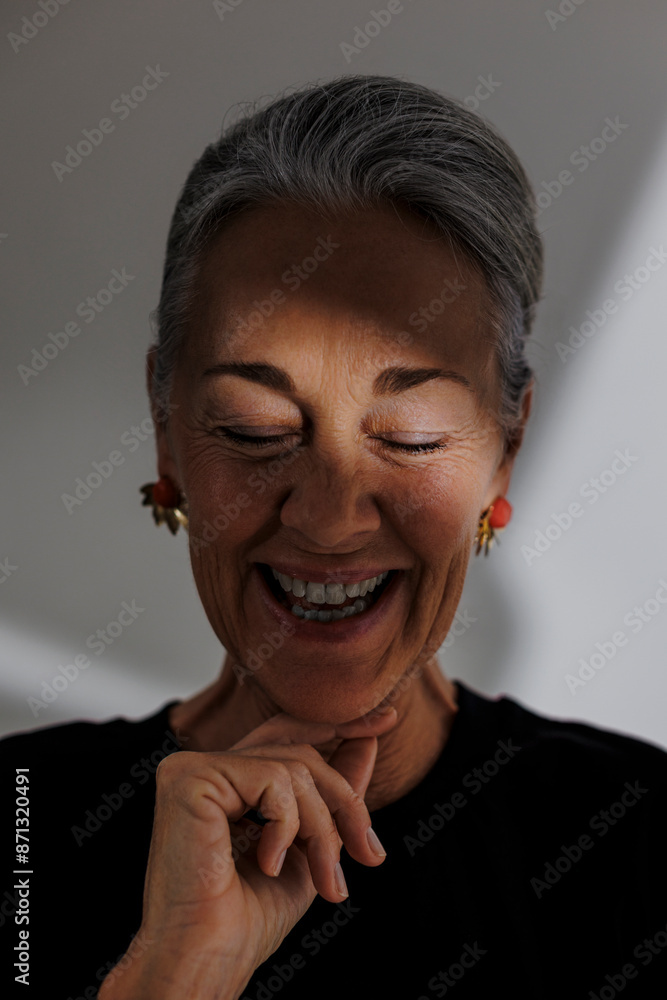 Radiant woman smiling with eyes closed in studio Radiant woman smiling with eyes closed in studio