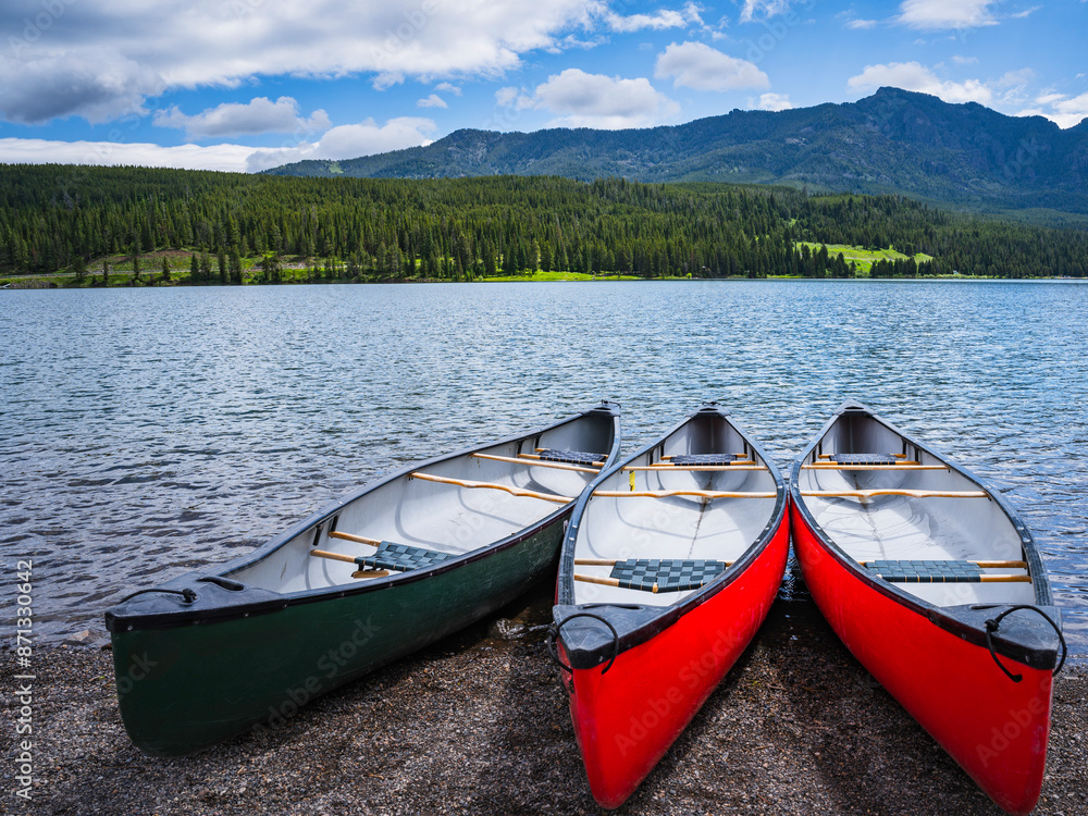Fototapeta premium Canoes in Hyalite Reservoir on Hyalite Canyon in Bozeman, Montana, USA: A beautiful and tranquil water sport and recreational site at an elevation of 6,699 ft
