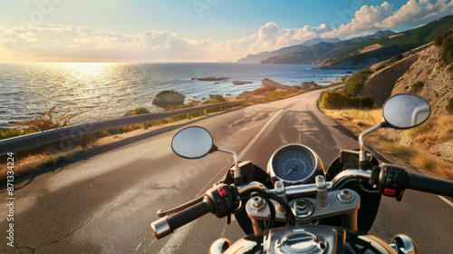 A breathtaking coastal road viewed from atop a motorcycle under a vibrant sky.