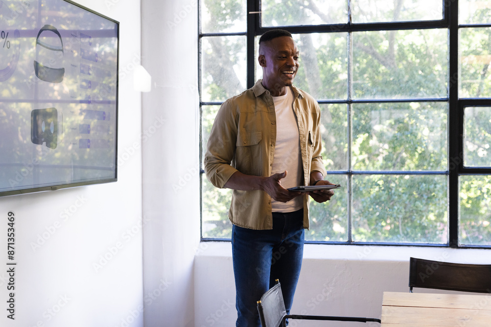 Presenting business ideas, man holding tablet and standing in modern office, copy space Presenting business ideas, man holding tablet and standing in modern office, copy space