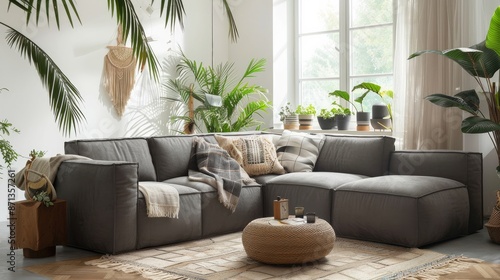 Stylish and design composition of living room with gray sofa, rattan armchair, cube, plaid, pillows, tropical plants, macrame and elegant accessories. Stylish home decor. Bright interior. Template.  © Farda Karimov