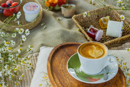 Beautiful white boho style decor. Picnic in nature on the grass under the tree photo