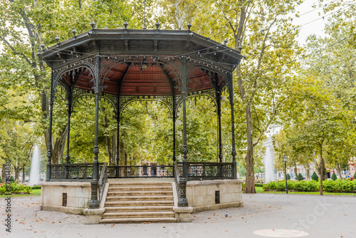 An elegant wrought iron gazebo with stairs in a park, accompanied by fountains in Zagreb, Croatia.