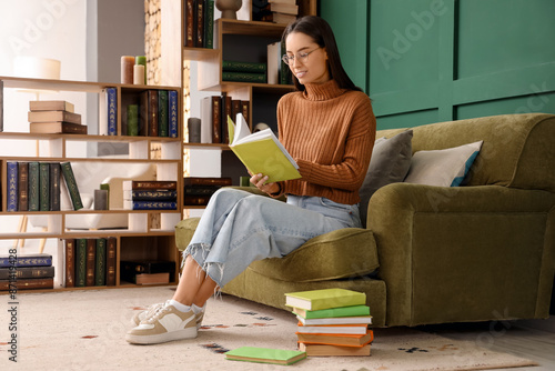 Young woman reading book on...