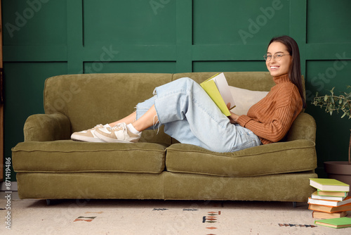 Young woman with book lying...