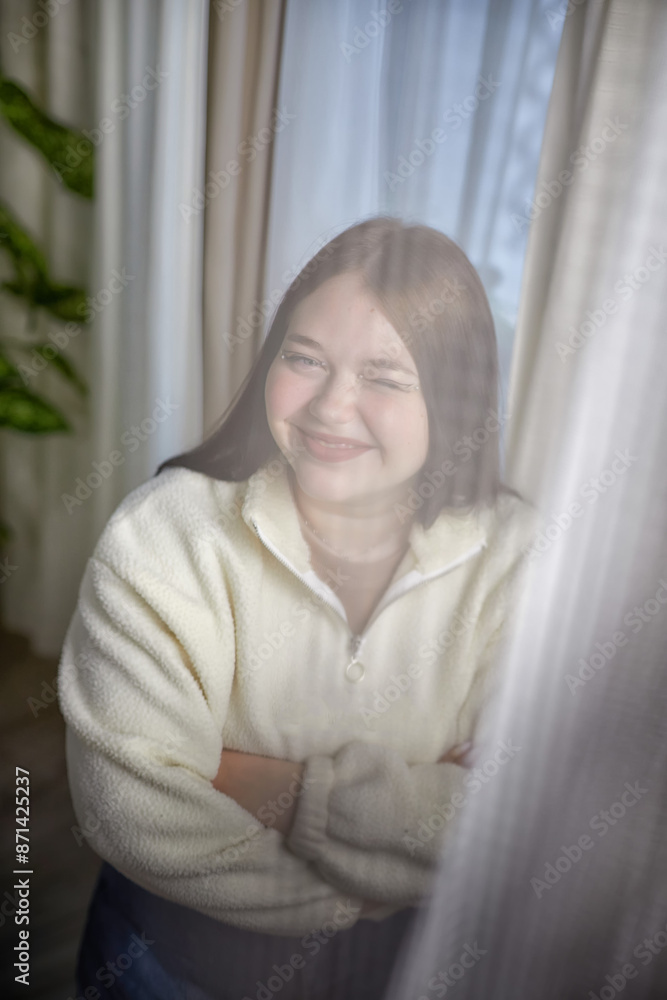 People and lifestyle concept. Body positiv. Indoor portrait of positive young Caucasian girl with chubby cheeks enjoying at home, smiling People and lifestyle concept. Body positiv. Indoor portrait of positive young Caucasian girl with chubby cheeks enjoying at home, smiling