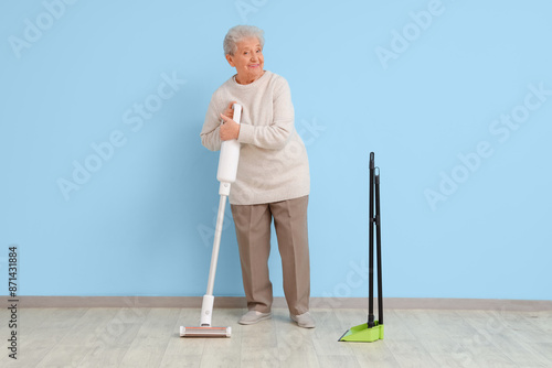 Senior woman with vacuum cl...