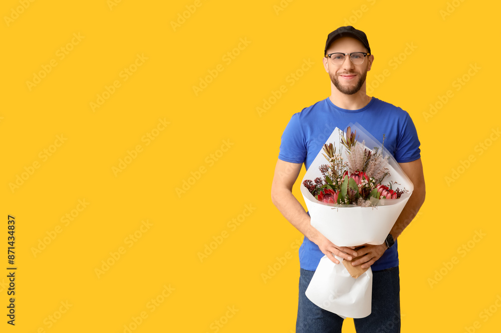Happy young delivery man with bouquet of beautiful flowers on yellow background Happy young delivery man with bouquet of beautiful flowers on yellow background