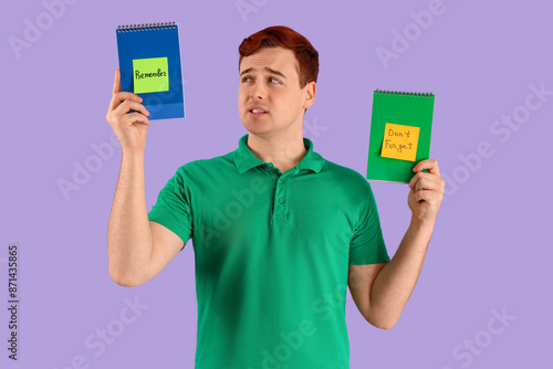 Young man holding notebooks...