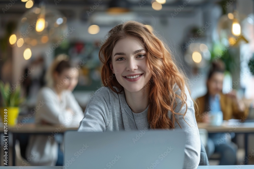 A woman is sitting at a table with a laptop in front of her A woman is sitting at a table with a laptop in front of her