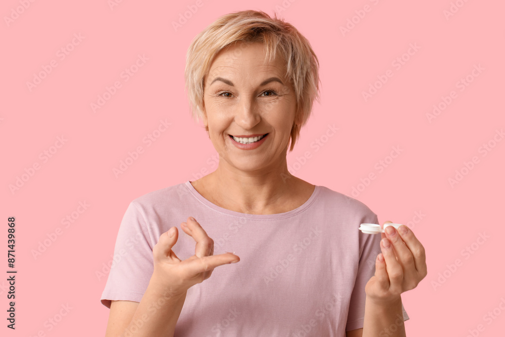 Mature woman with contact lens and case on pink background Mature woman with contact lens and case on pink background