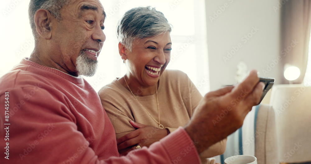 Fototapeta premium Laugh, phone and senior couple in home together for funny joke, meme or reading comedy story. Retirement, man and woman on mobile in lounge for news, streaming video and relax for connection on email