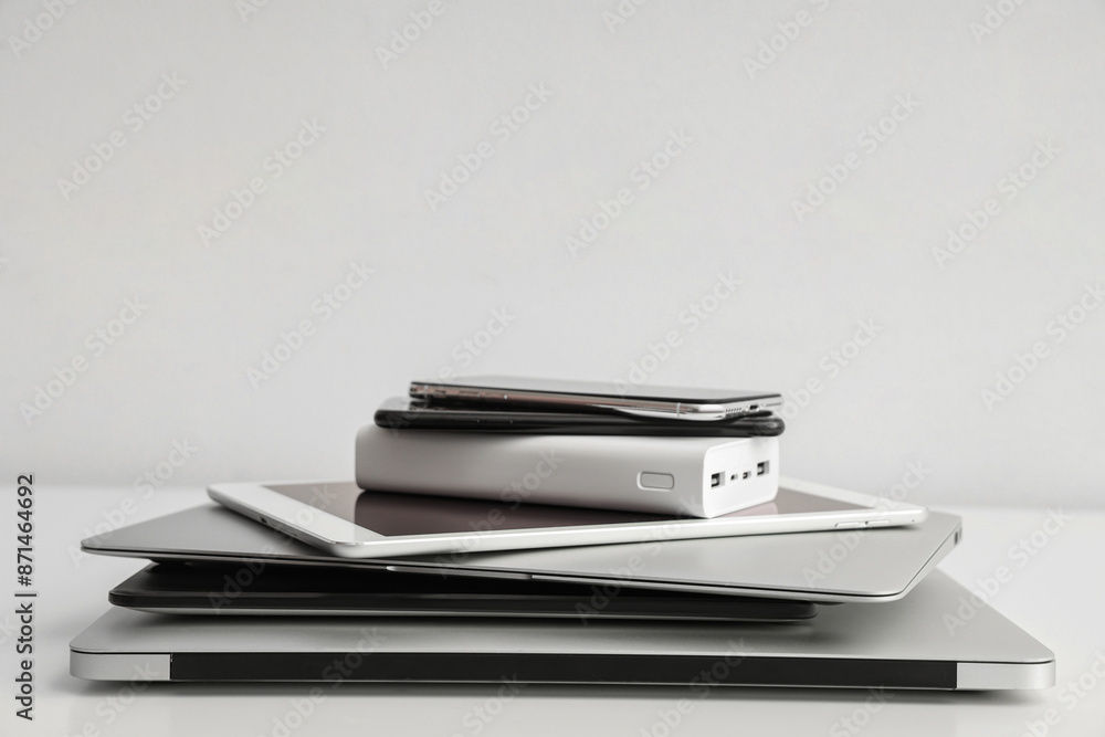 Stack of different modern gadgets on light background Stack of different modern gadgets on light background