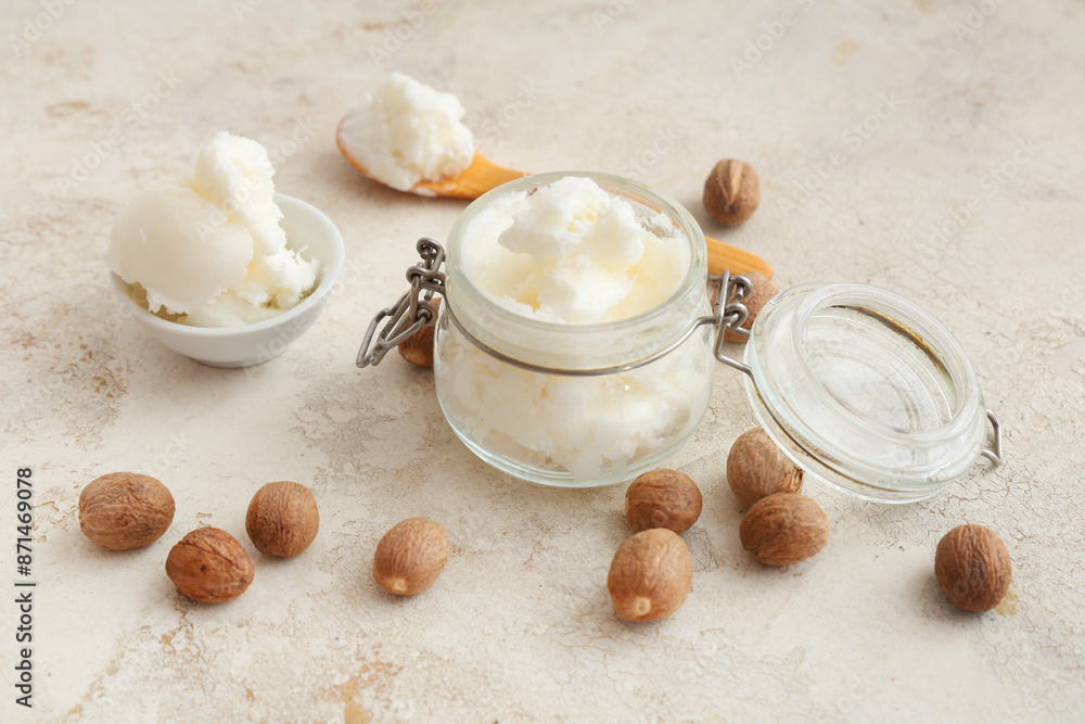 Glass jar with shea butter and nuts on grunge background Glass jar with shea butter and nuts on grunge background