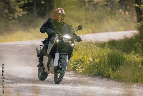 Obraz na płótnie Modern adventure motorcycle on a ride on gravel surface. Motorcycling in nature or offroad, enjoying freedom. Motorbike in the woods. Making a turn w salonie