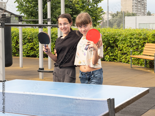 table tennis players playing ping pong outdoor with table tennis rackets