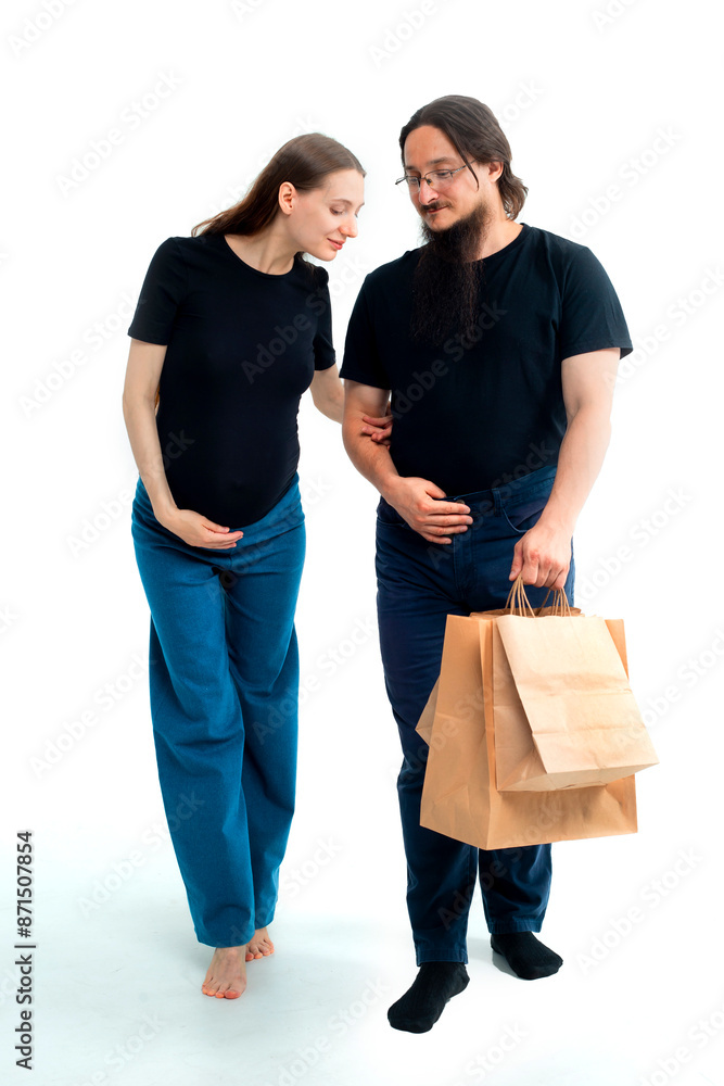 Portrait happy young pregnant woman and her husband with shopping bags and touching her big belly isolated on white background. Pregnancy shopping concept happy young family with shopping bags