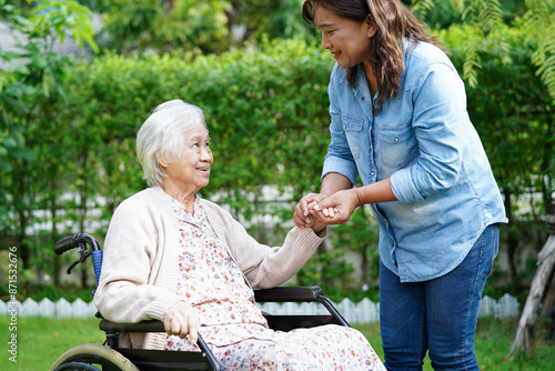 Caregiver help Asian elderly woman disability patient sitting on wheelchair in park, medical concept.