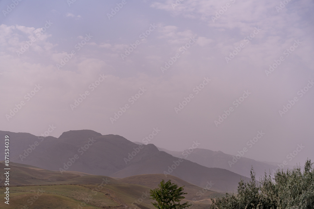 Obraz premium A mountain range with a cloudy sky in the background