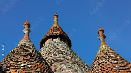 Close-up shot of the unique conical roof structure of an oast house against a bright blue sky showcasing its distinct architectural design and craftsmanship. photo