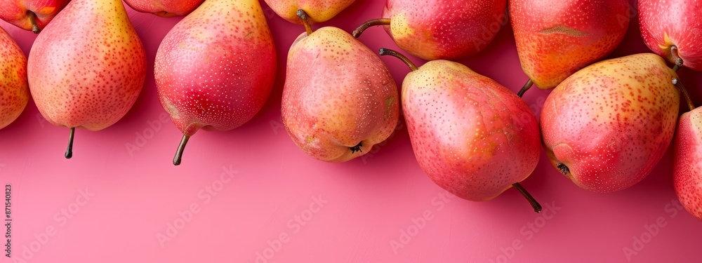 A collection of red pears arranged together on a pink backdrop A collection of red pears arranged together on a pink backdrop