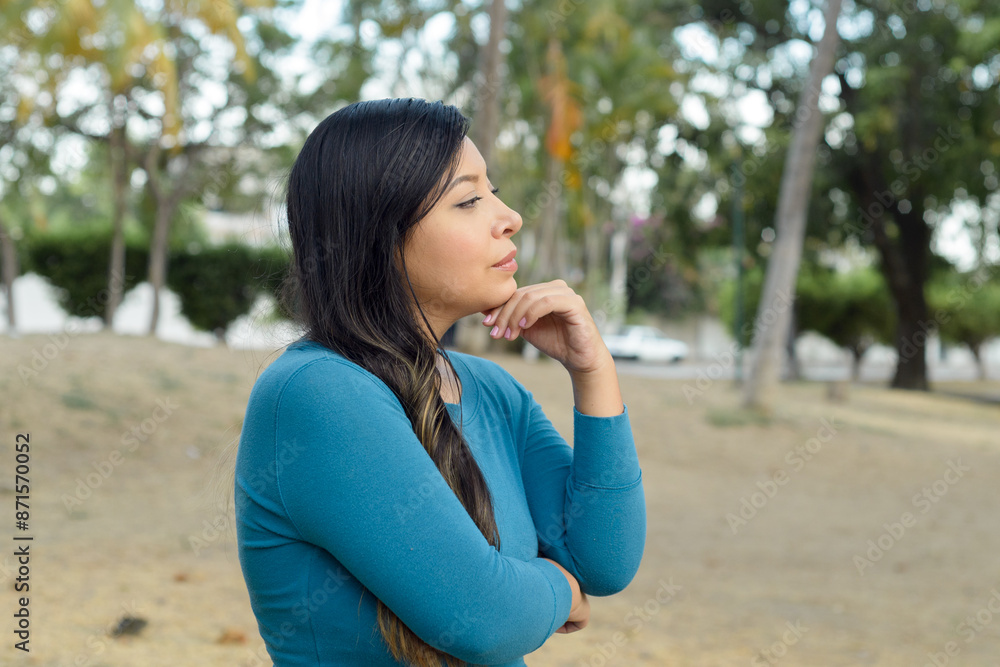 Woman in a public park with an attitude of preoccupation, pensive. Woman in a public park with an attitude of preoccupation, pensive.