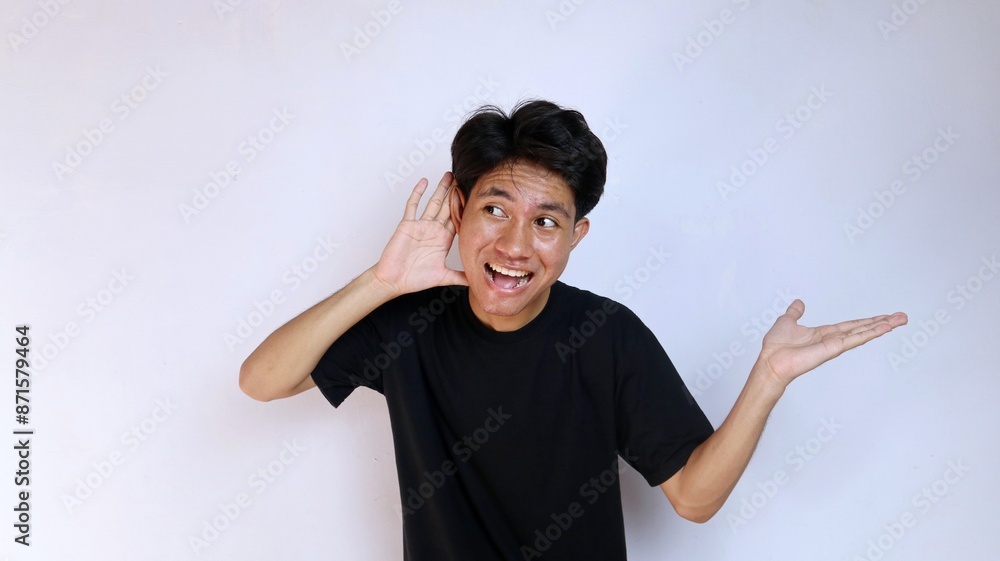 Excited young Asian man wearing a black shirt gesturing with his hands ...