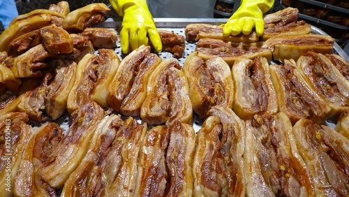 Cooked pork ribs are meticulously arranged on a perforated surface, signifying the culinary process in an industrial kitchen.