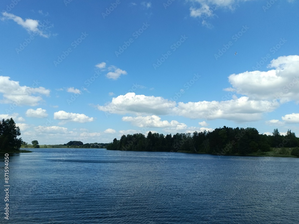 Bubiai lake during sunny day. Lake with small waves. Sunny day with white and gray clouds in sky. Nature. Bubiu ezeras. Bubiai lake during sunny day. Lake with small waves. Sunny day with white and gray clouds in sky. Nature. Bubiu ezeras.