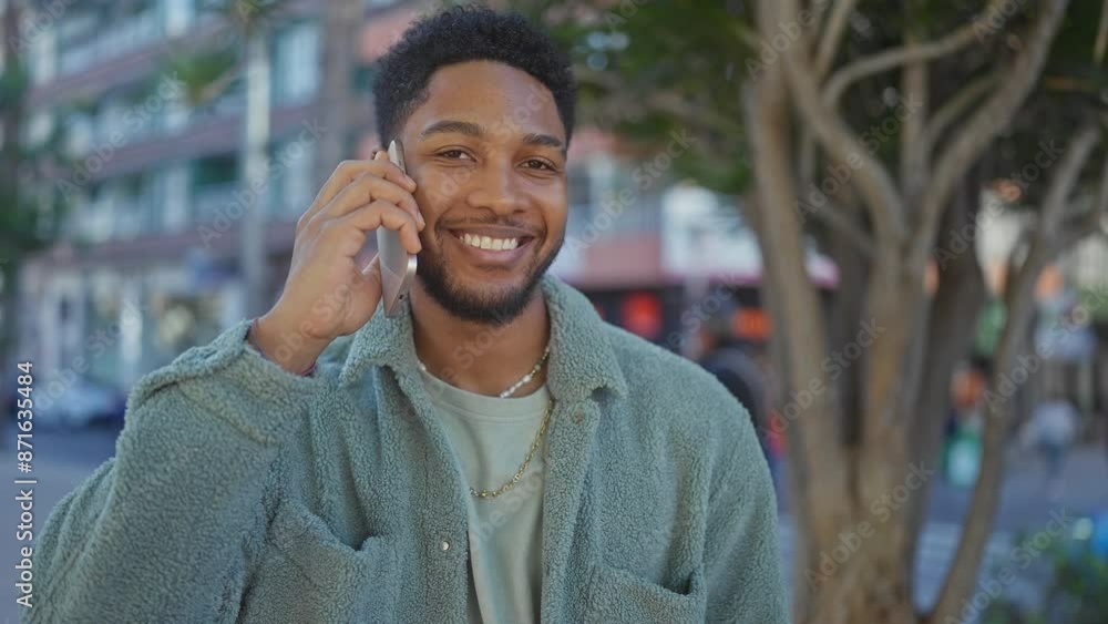 Smiling man talking on phone in urban environment Smiling man talking on phone in urban environment