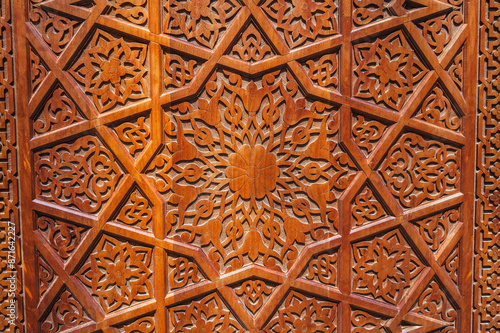 traditional asian Uzbek patterns ornament on wooden carved door in Uzbekistan close-up photo