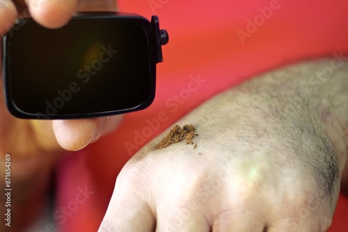 Obraz na plátně Cropped hand of man holding german snuff tobacco.