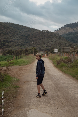 Teen boy on winter walk along country lane © Caseyjadew