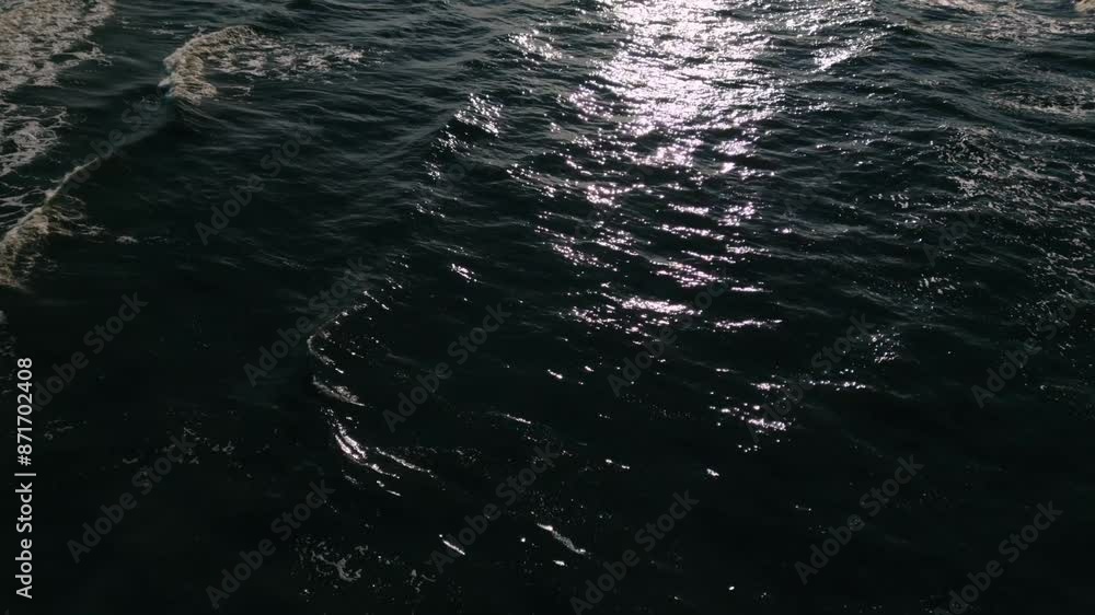 A top view of the sea reveals mysterious, dark waters with a pattern of rippling waves and peaceful sunlight reflecting on the surface, creating a mesmerizing and tranquil scene. Helsinki, Finland A top view of the sea reveals mysterious, dark waters with a pattern of rippling waves and peaceful sunlight reflecting on the surface, creating a mesmerizing and tranquil scene. Helsinki, Finland