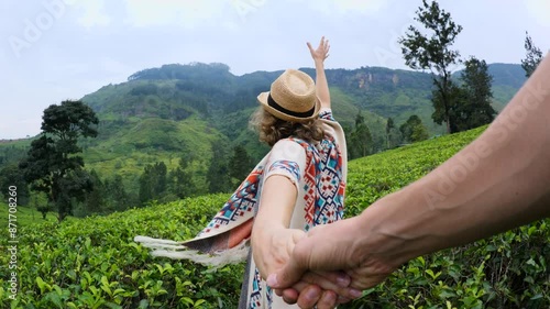 Follow me. Woman tourist in hat on highland Ceylon tea plantations. Cinematic shot happy traveler walking through picturesque green plantation In every movement woman on plantation happiness to travel