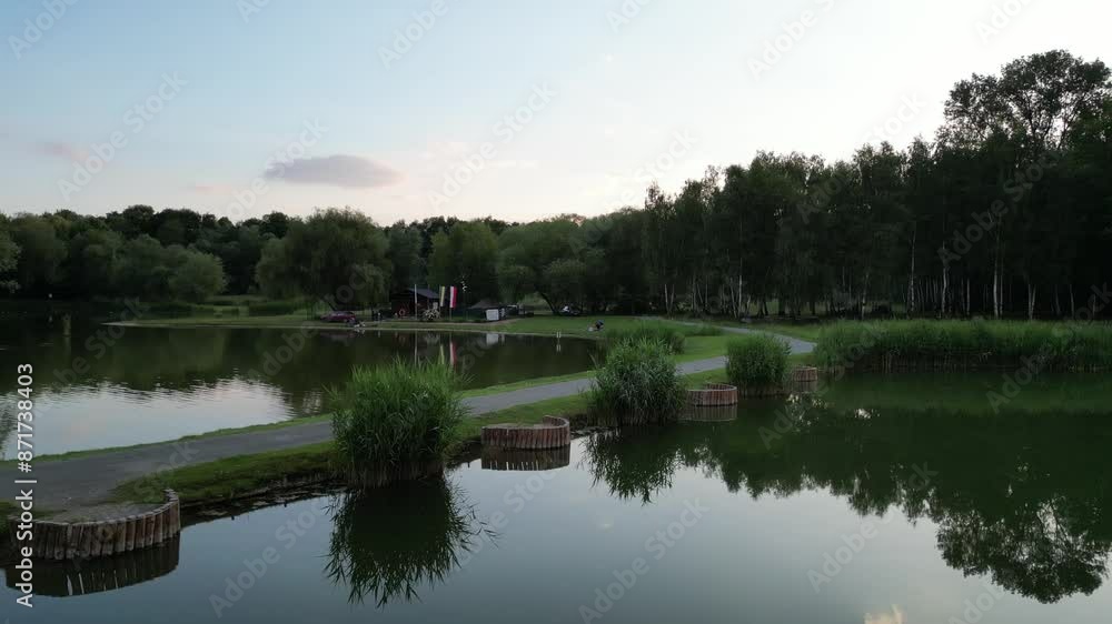 Small green lake surrounded by trees while sky reflecting in water - aerial view 4K Small green lake surrounded by trees while sky reflecting in water - aerial view 4K
