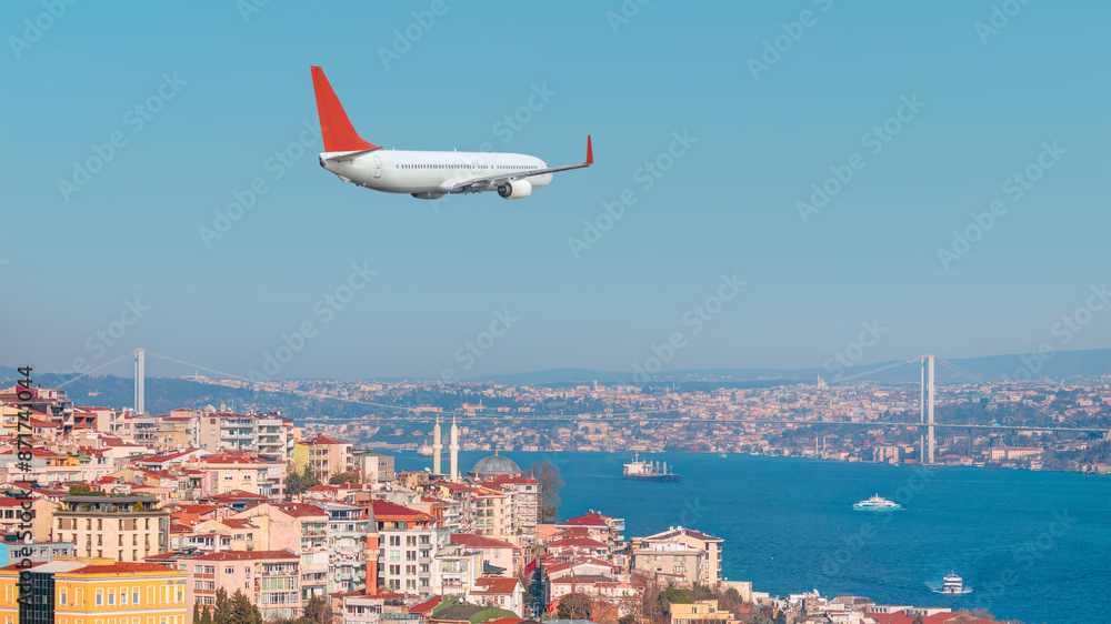 Fototapeta premium A passenger airplane is flying over istanbul city with blue Bosphorus sea and bridge