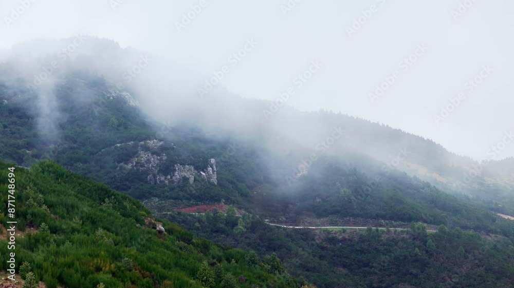 Low clouds and fog above a rocky green mountain in Madeira Portugal, aerial footage Low clouds and fog above a rocky green mountain in Madeira Portugal, aerial footage