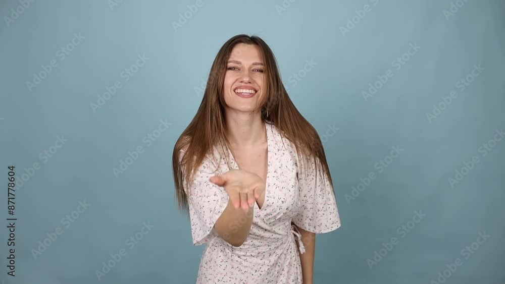 Woman Sending an Air Kiss, Smiling, Wearing a Light Summer Dress on a Blue Background Slow Motion Woman Sending an Air Kiss, Smiling, Wearing a Light Summer Dress on a Blue Background Slow Motion