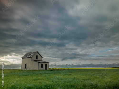 Abandoned house in a vast green field in Aberdeen, Saskatchewan, Canada