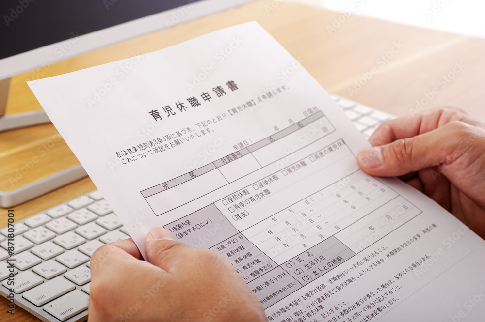 Obraz premium 育児休暇の申請書を見つめる男性