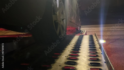 A black damaged car involved in accident is being towed by a tow truck ramp