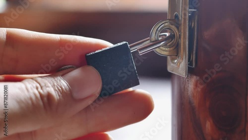 Close-up of hand unlocking the key of a wooden box locked