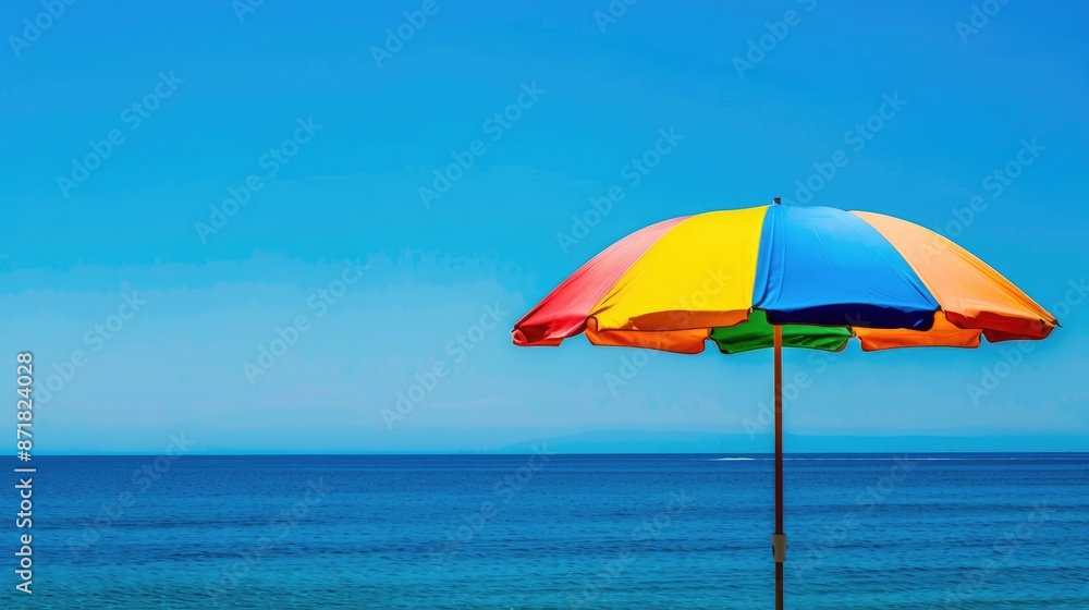 A colorful beach umbrella with the ocean in the background, space for text. A colorful beach umbrella with the ocean in the background, space for text.